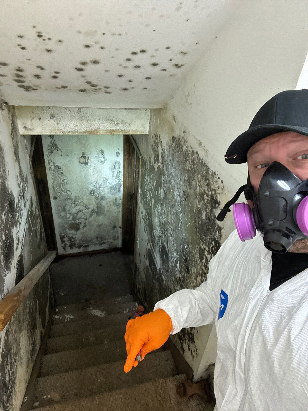 Photo of technician displaying severe mold in stairway.